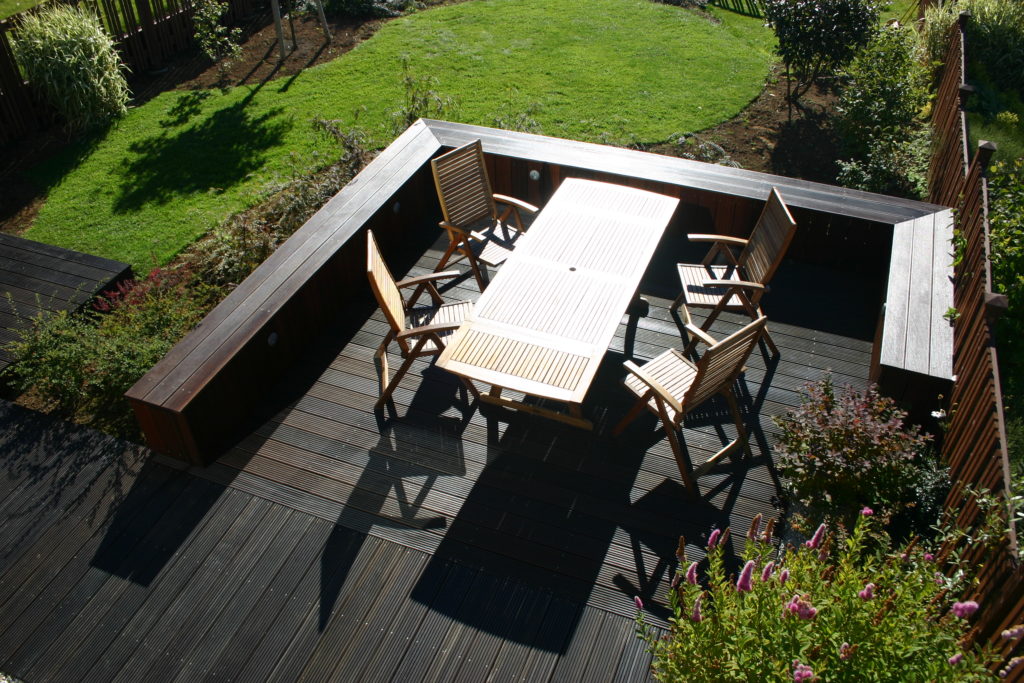 An enclosed area with garden furniture on a dark deck