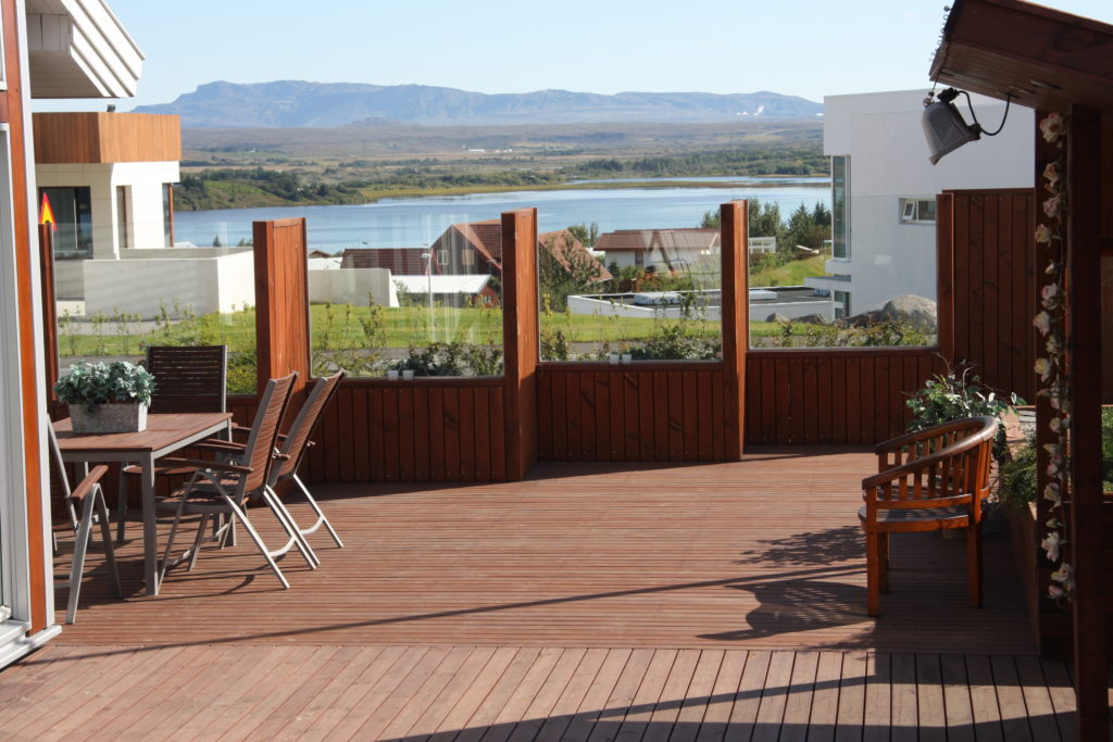 A decked garden area with a glass and timber wall.